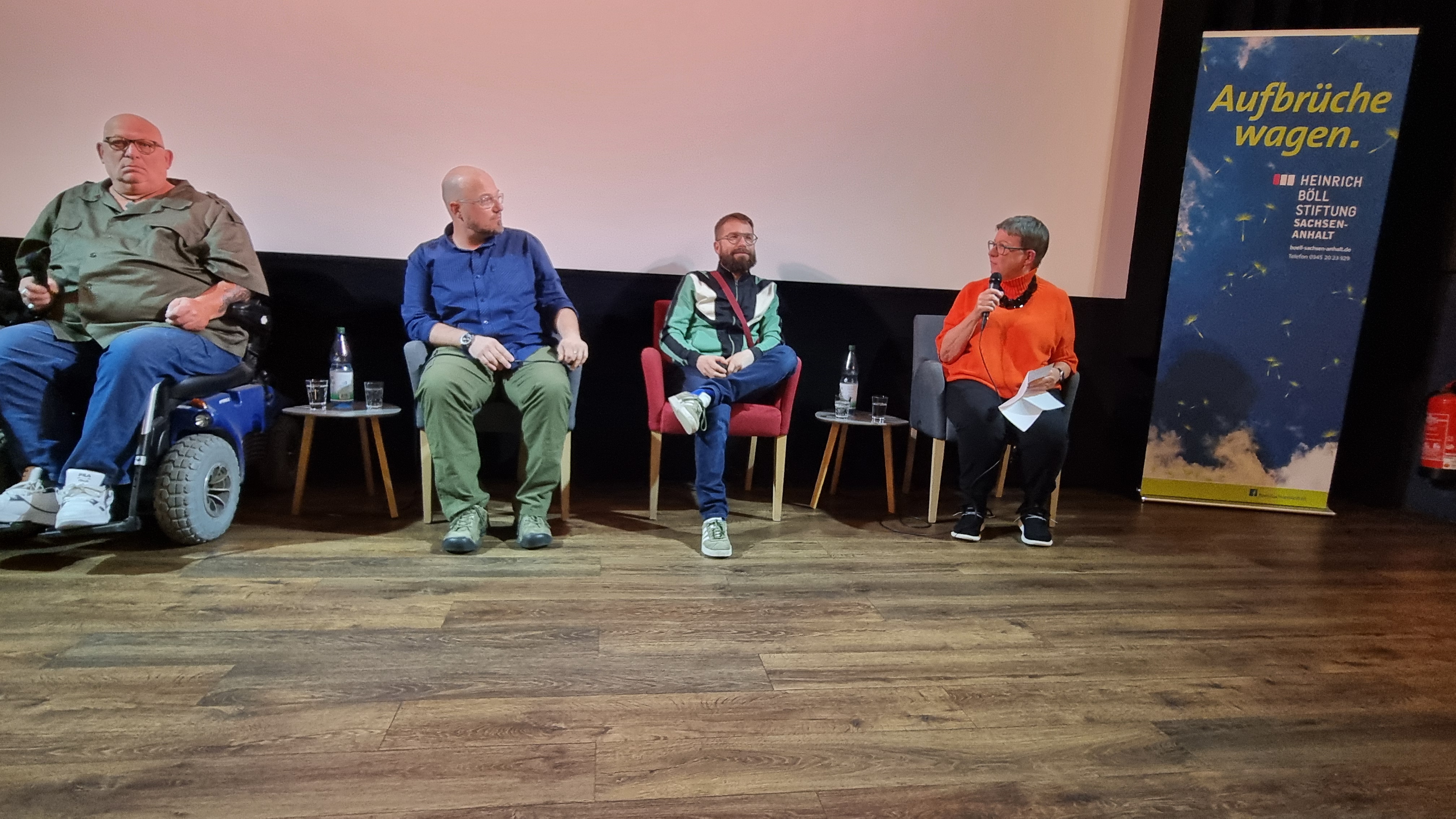 Ein Podiumsgespräch mit verschiedenen Menschen im Kinosaal